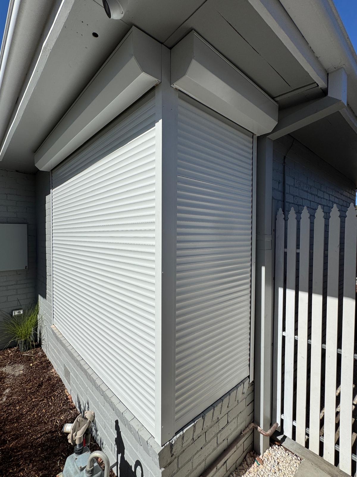 White roller shutter on grey brick home