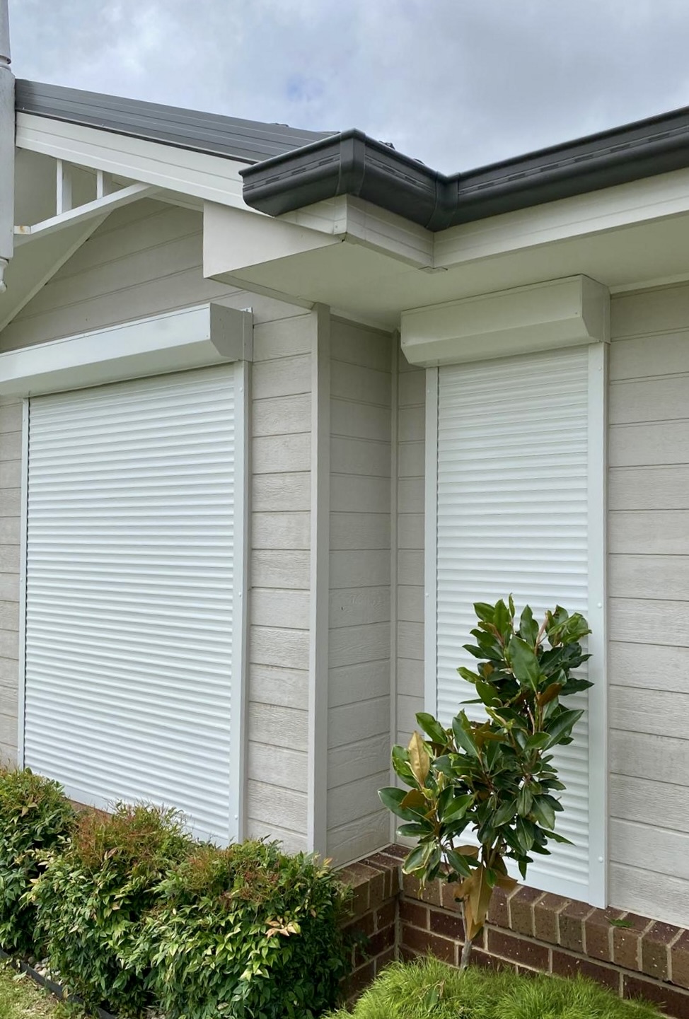 White roller shutters on weatherboard home