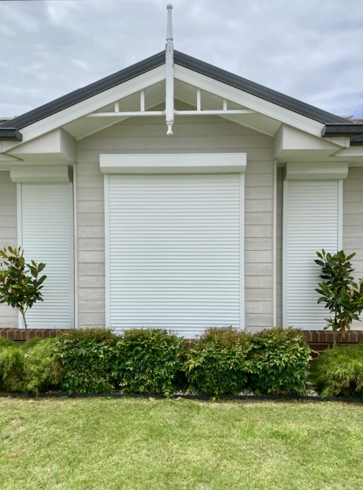 White roller shutter on landscaped home